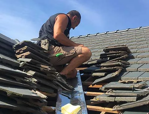 Couvreur réalisant des travaux de couverture en Isère
